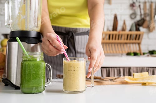 Preview: Close up of a young woman holding a jar of fruit smoothie