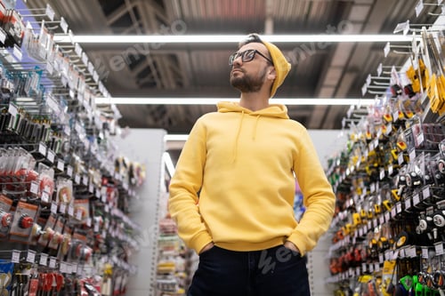 Preview: a man in a hardware store examines the assortment of goods on the shelves