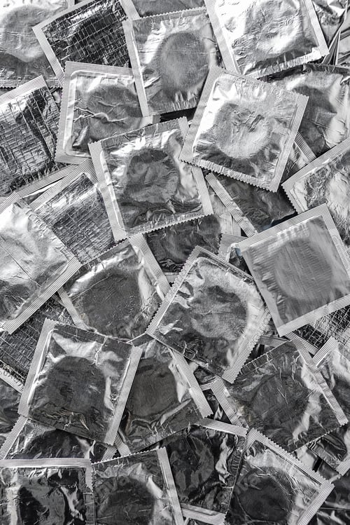 Preview: Top view of background with pile of silver condoms