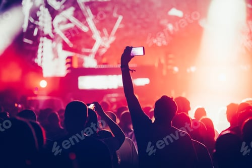 Preview: Cheering crowd with hands in air at music festival