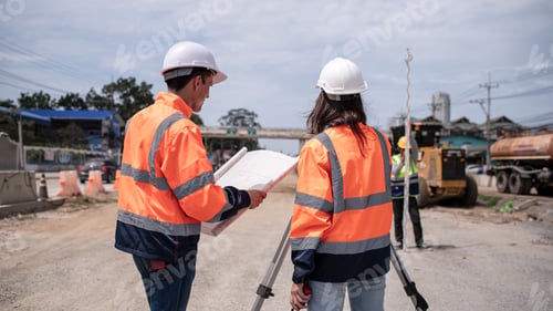 Preview: Engineers Surveyor wearing safety uniform ,helmet with equipment theodolite to measurement positioni