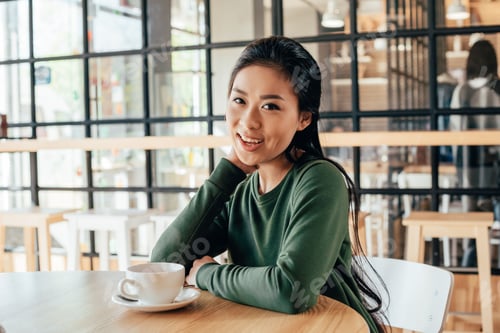 Preview: Portrait of young asian woman spending time in cafe