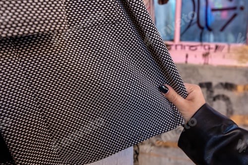 Preview: Female customer is picking a stylish black and white dress in her hands in the store