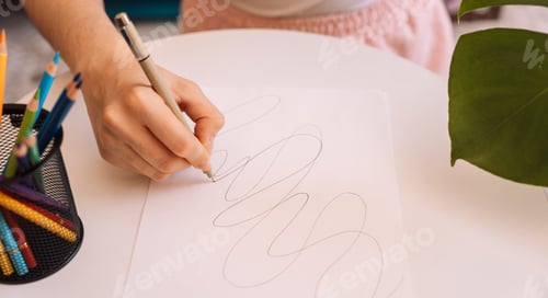 Preview: Lady draws with a black pen on a white sheet