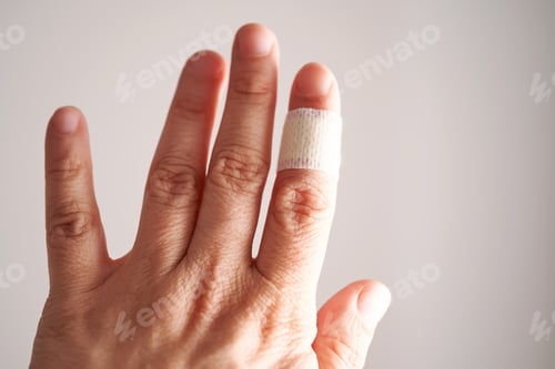Preview: Applying an adhesive plaster to a finger. Close-up.
