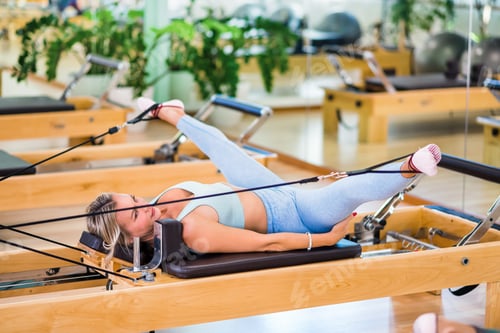 Preview: Woman stretching legs on pilates reformer