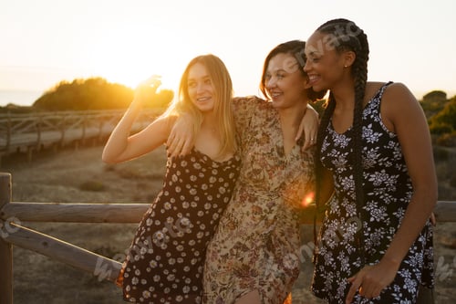 Preview: Smiling diverse women embracing on wooden boardwalk