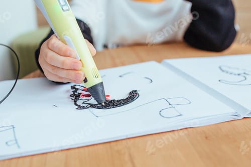 Preview: a blonde boy draws with a 3D pen .on the back wall is a wooden background