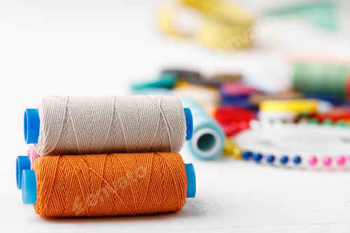 Preview: Colorful sewing accessories on white wooden table