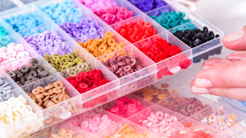 Preview: Woman's Hands Amidst a Rainbow Array of Beads for Jewelry Crafting