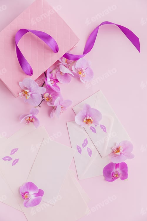 Preview: Pink gift bag and orchid flowers on light pink background