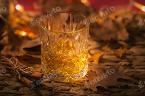 Preview: Whiskey, brandy or liquor, spices and autumn decorations on dark background