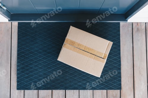 Preview: A Brown Cardboard Box Sitting on a Welcome Mat at a Doorstep, Ready for Delivery