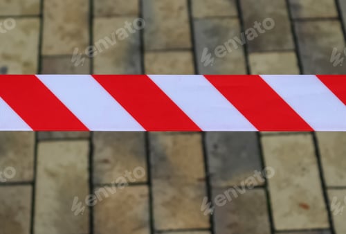 Preview: Closeup shot of red and white warning tape with brick walls background