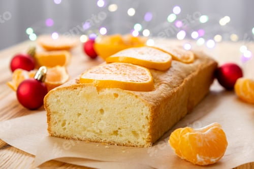 Preview: Moist tangerine pound cake on parchment on rustic wooden background