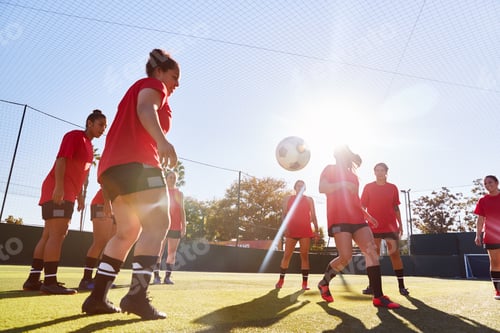 Preview: Womens Football Team Kicking Ball Whilst Training For Soccer Match On Outdoor Astro Turf Pitch
