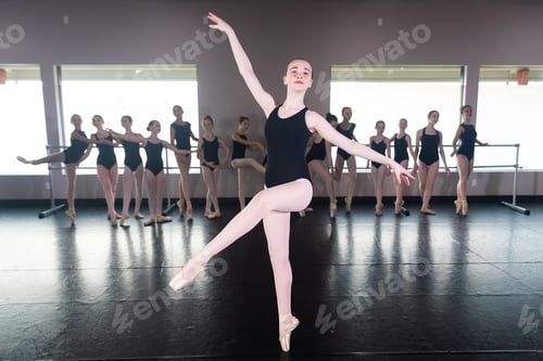 Preview: Teenage girl in ballet dance studio poses with the rest of the class behind her
