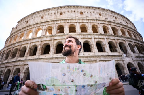Preview: Caucasian man holding map outside the Colosseum in Rome