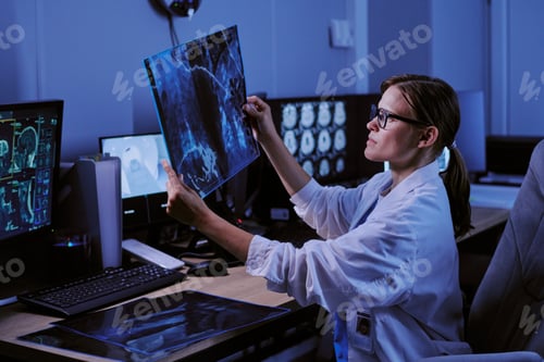 Preview: Caucasian Young Adult Woman Radiologist Examining X Ray Scan in Hospital Office