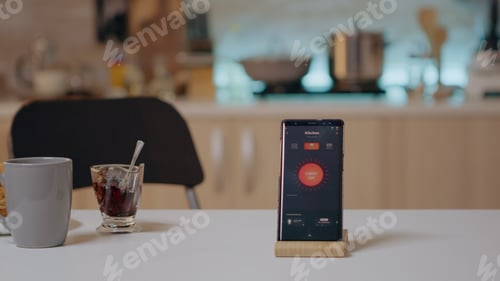Preview: Smart home application on phone placed on kitchen desk in empty house