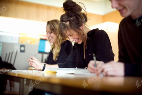 Preview: Cheerful students sitting at desk in classroom