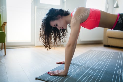 Preview: Young attractive sportswoman doing exercises at home