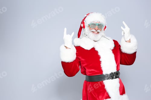 Preview: Santa Claus listening to Christmas music on color background