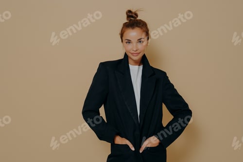 Preview: Attractive young model female in black suit with hair tied up in high bun