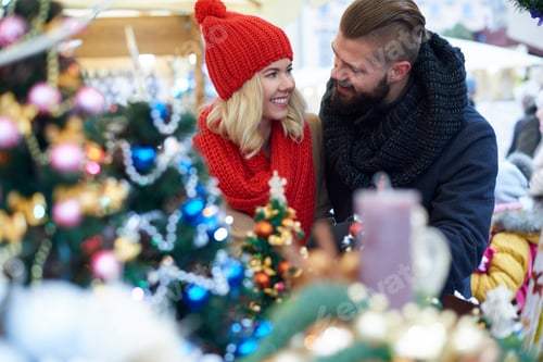 Preview: Couple outdoors surrounded with Christmas ornaments
