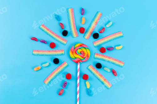 Preview: a top view marmalades and lollipops colorful delicious on the blue background rainbow color sugar