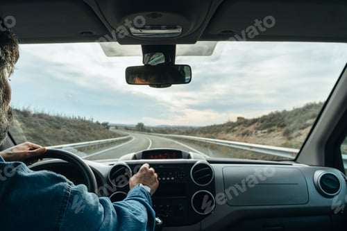 Preview: man driving a van from the rear view on the road.