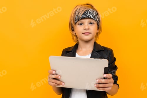 Preview: Stylish young boy in black jacket and white t-shirt serfing internet with his tablet