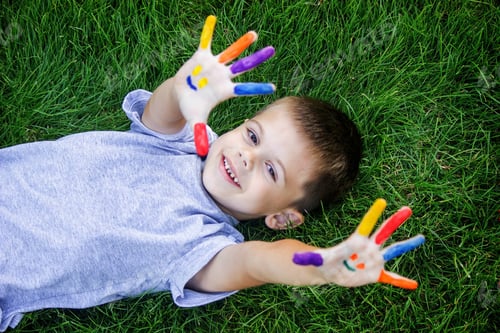 Preview: Children's hands in the colors of summer, a smile on the boy's palm