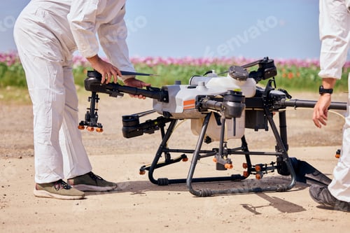 Preview: Male operators set up the agro-drone, checking everything before starting to fly.