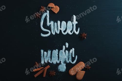 Preview: Words Sweet Magic made with sugar. Cookies and crumbs on a dark background. Food typography concept