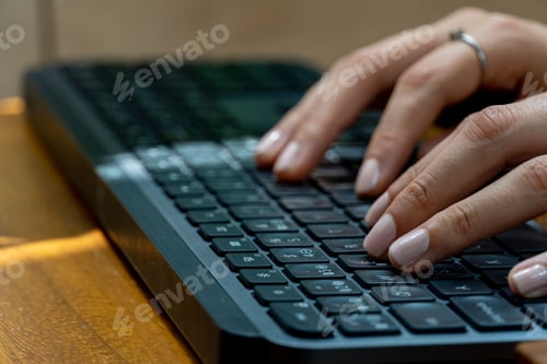 Preview: Woman's hand typing on a keyboard, work from home concept