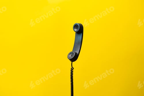 Preview: a simple dark old telephone handset with cable. on pastel background