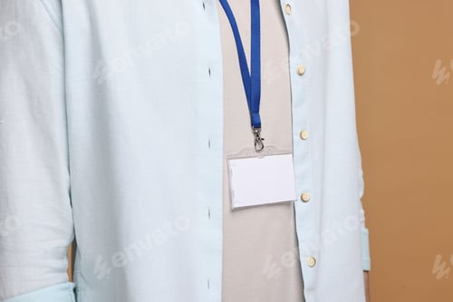 Preview: Man with empty badge on beige background, closeup
