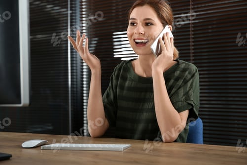 Preview: Female technical support operator talking on mobile phone at workplace