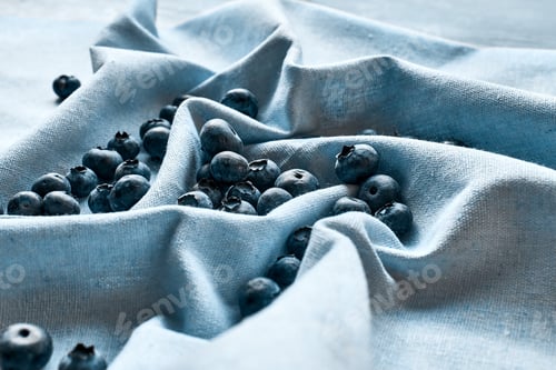 Preview: Fresh organic blueberries. Juicy ripe bilberry on blue cloth.