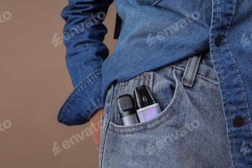 Preview: Vape Device in Jeans Pocket with Denim Shirt on Brown Background