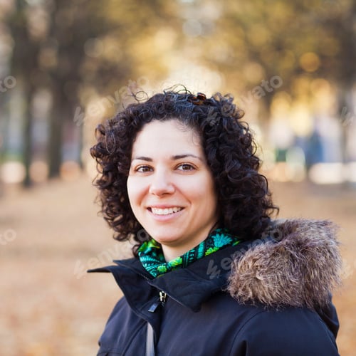 Preview: Portrait of happy woman with curly hair at park