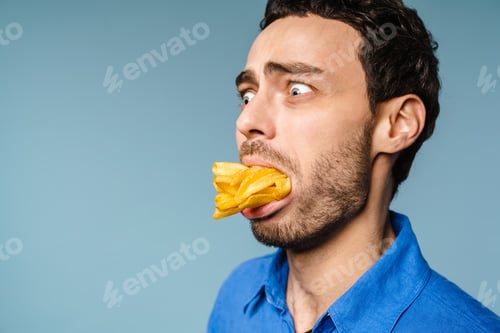 Preview: Shocked handsome guy posing with french fries in his mouth