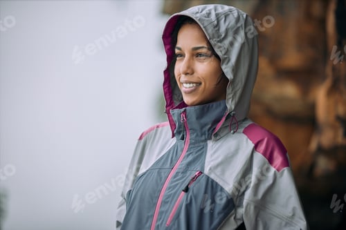 Preview: Its really beautiful up here. Shot of a woman wearing her rain jacket while out hiking.