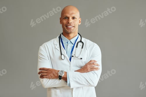 Preview: Young African American medical expert with arms crossed against background.