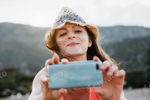 Preview: Smiling Woman Taking a Photo Outdoors