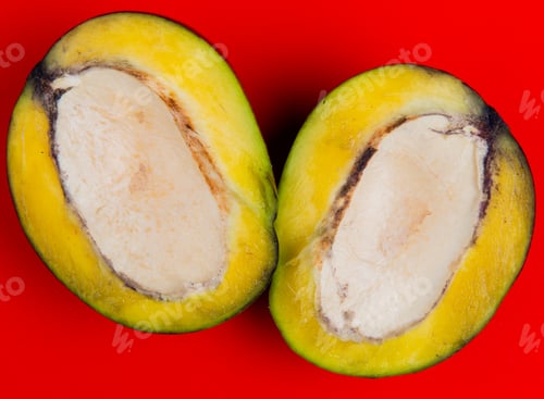 Preview: close-up view of half cut mango on red background