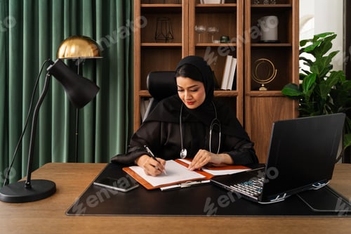 Preview: Muslim female doctor working at her desk in modern office