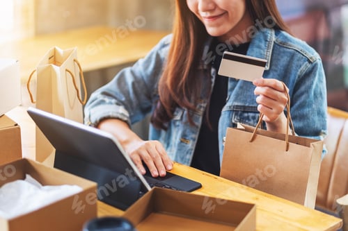 Preview: a young asian woman using tablet pc and credit card for online shopping