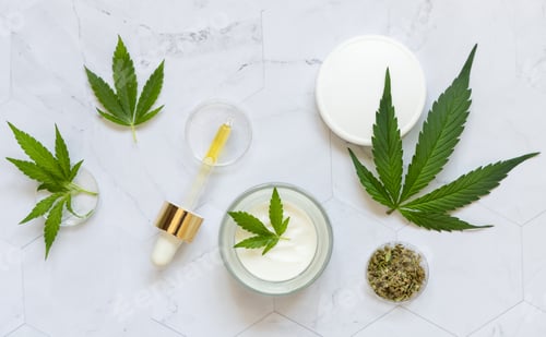 Preview: Pipette with CBD oil, cream jar and dry tea near green cannabis leaf. Alternative healthcare